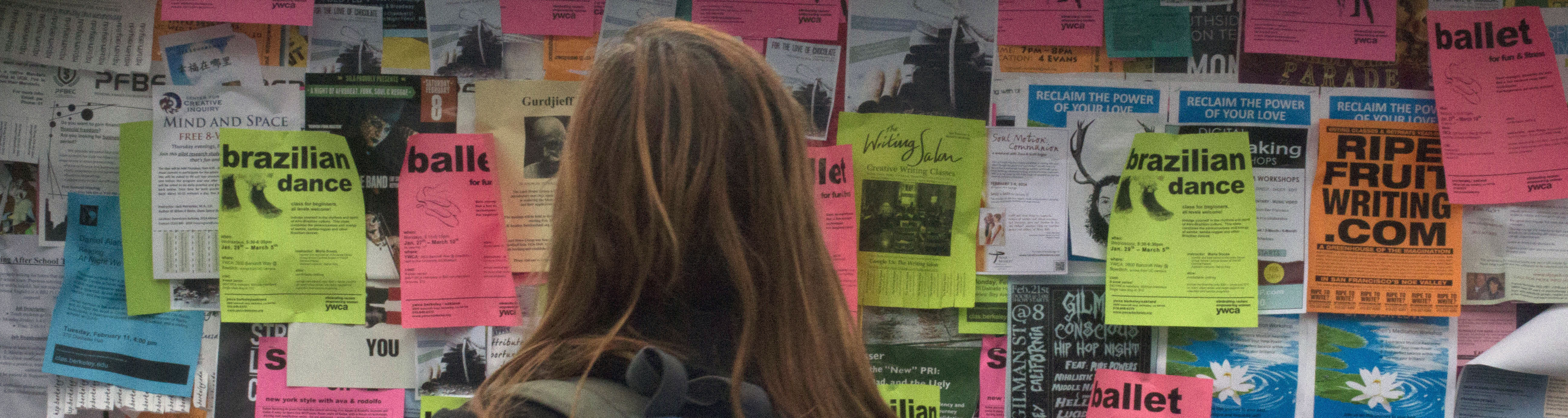 Student looking at fliers on Sproul Plaza.